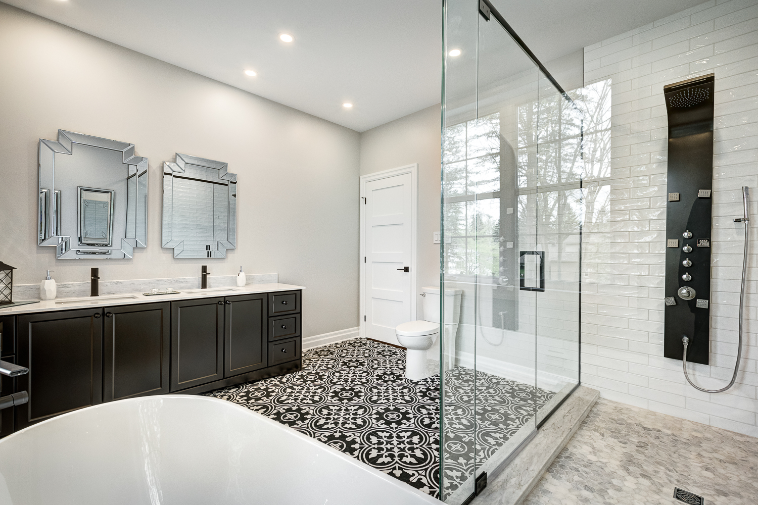 View of bathroom vanity and shower in black and white bathroom